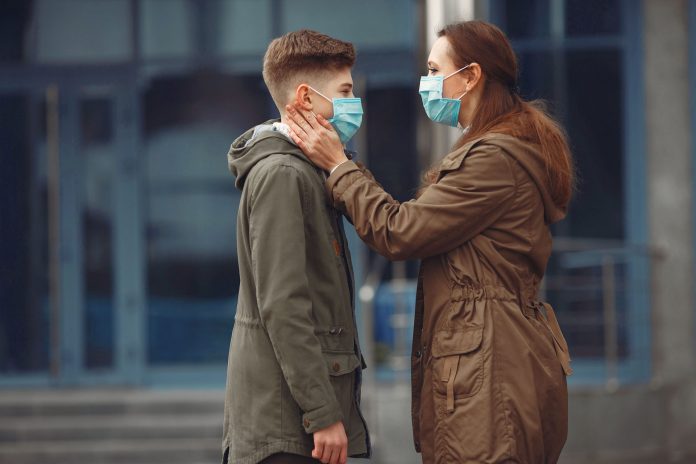 A boy and mother are wearing protective masks